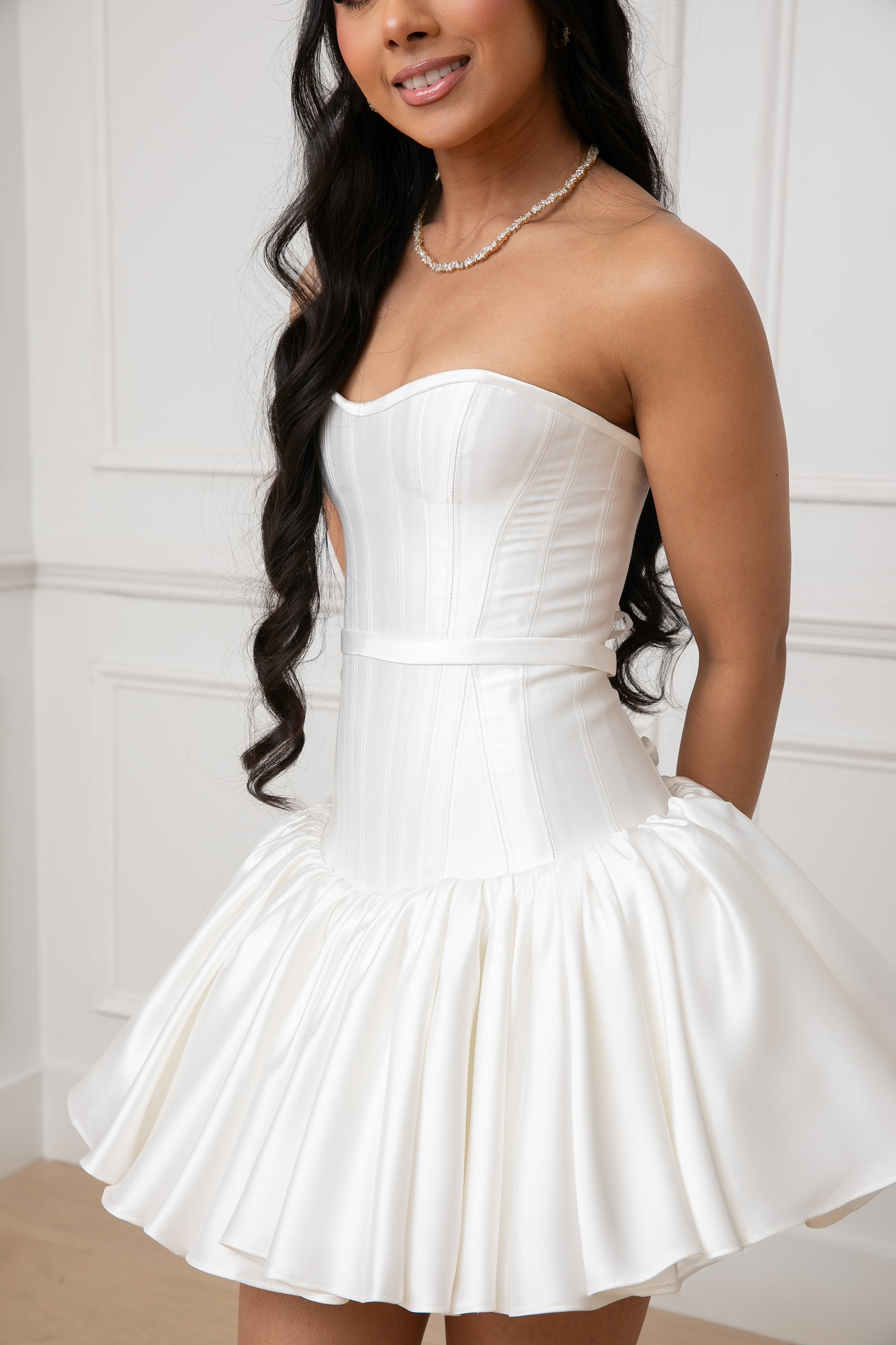 The Duchess Dress by Brunell by Shar, close-up of the white satin structured corset bodice, with unique panel design, strapless neckline, and gathered drop-waist silhouette.